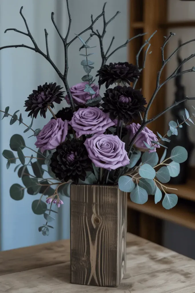 Rustic wooden vase filled with dark purple roses, dahlias, and painted branches for a gothic Halloween arrangement.